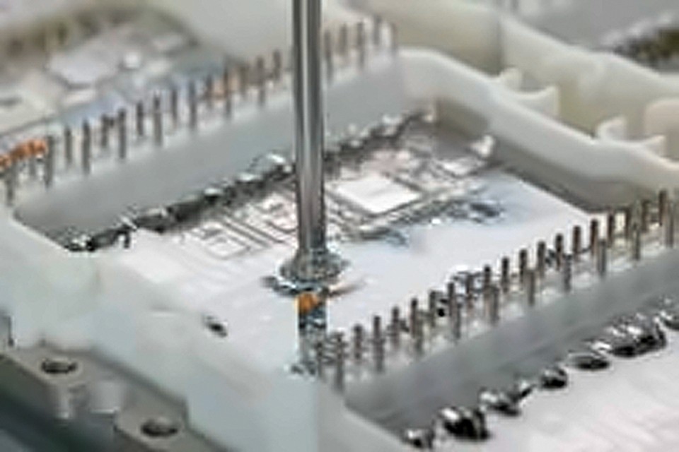 Silikon-Vergussmasse wird auf eine Elektronik-Leiterplatte dosiert